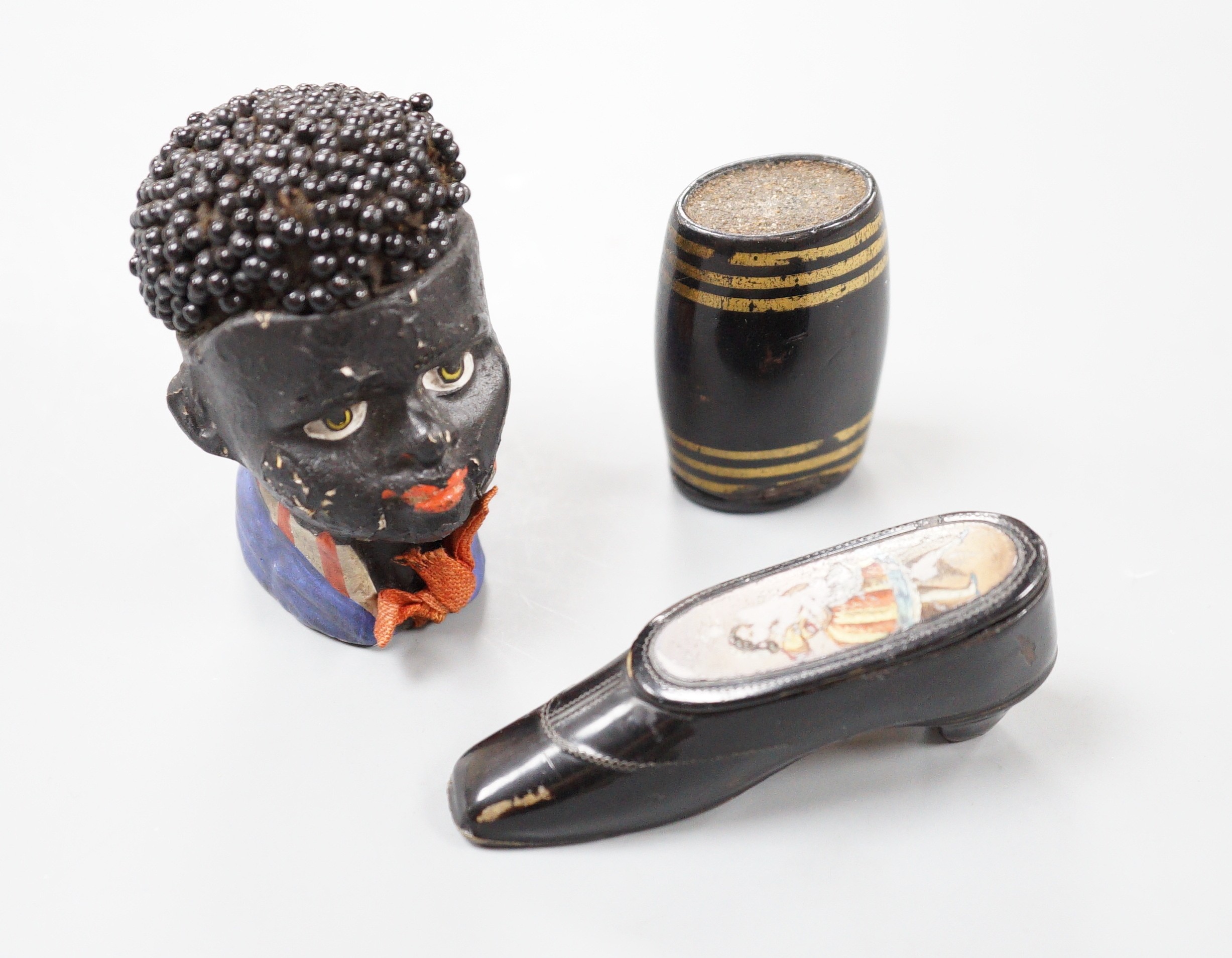 A Victorian japanned Papier mache snuff shoe, 7.5 cm, a similar Vesta case and novelty pin-cushion (3)